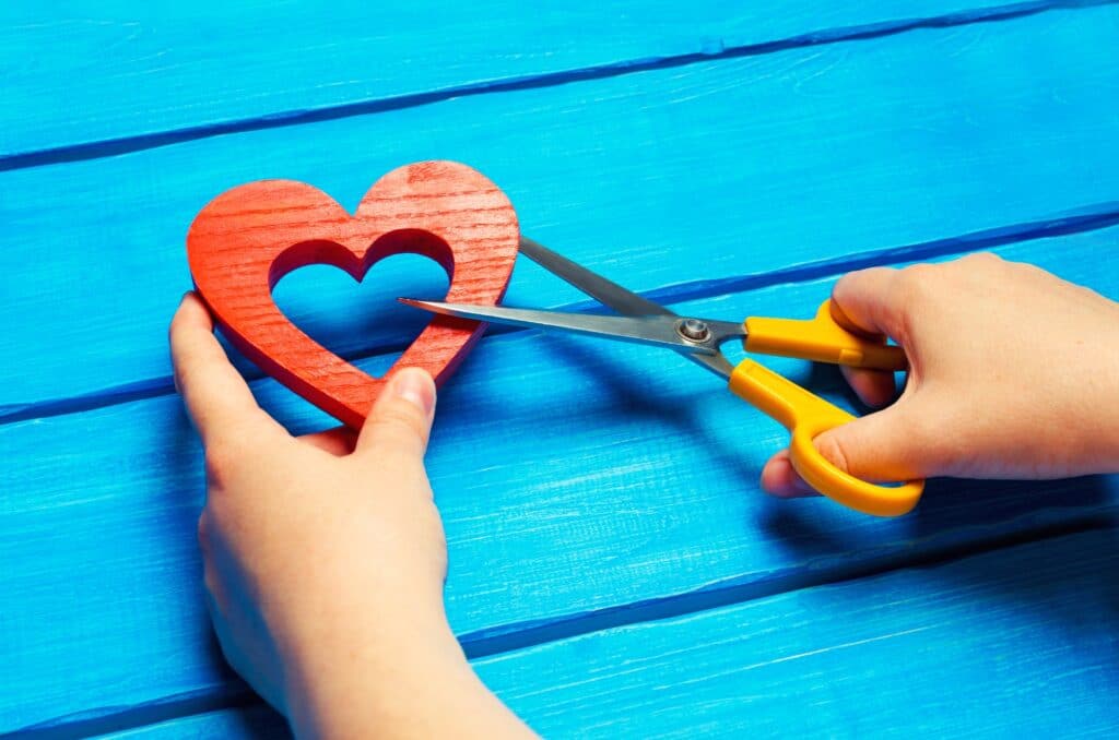 girl cuts the heart with scissors, the concept of breaking relations, quarrels and divorce
